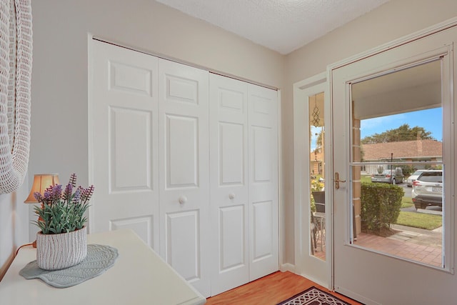 entrance foyer with hardwood / wood-style floors and a textured ceiling