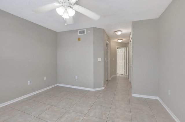 tiled spare room with ceiling fan