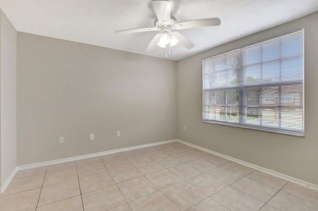 tiled spare room featuring ceiling fan