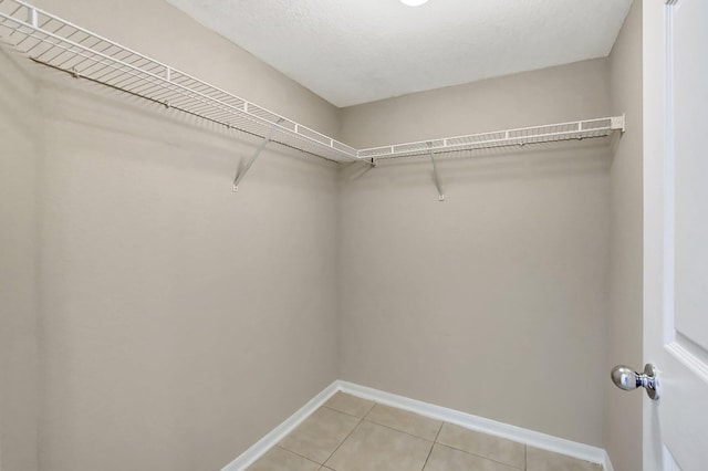 walk in closet with light tile patterned floors