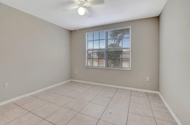 empty room with ceiling fan and light tile patterned floors