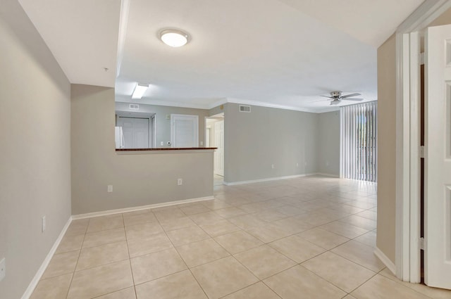 spare room with ornamental molding, light tile patterned flooring, and ceiling fan