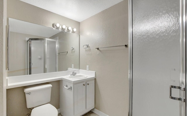 bathroom with an enclosed shower, vanity, toilet, and a textured ceiling