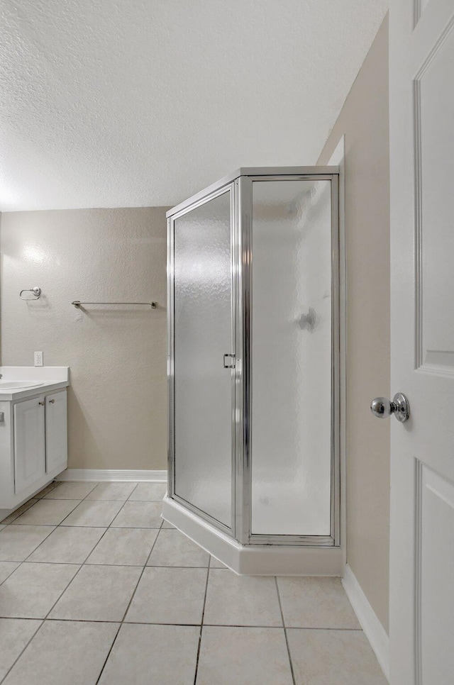 bathroom with vanity, tile patterned floors, a textured ceiling, and walk in shower