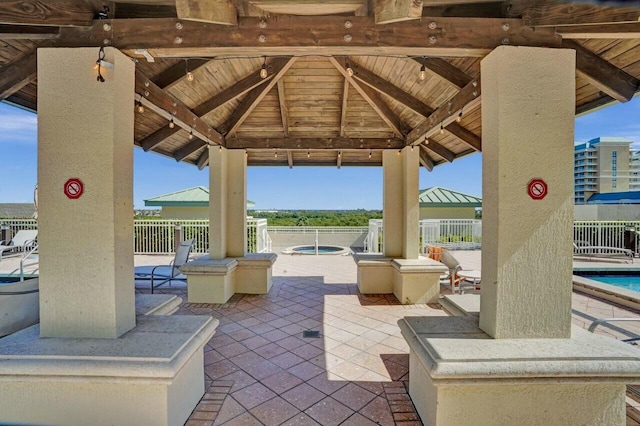 view of patio with a gazebo and a pool with hot tub