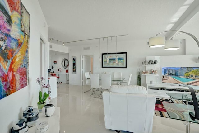 living room featuring rail lighting and light tile patterned floors