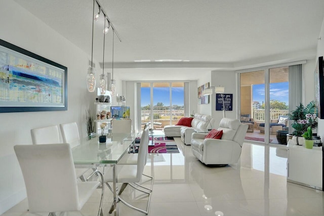 dining room with expansive windows, track lighting, a textured ceiling, and light tile patterned floors