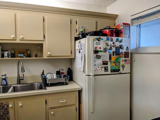 kitchen with open shelves, light countertops, a sink, and freestanding refrigerator