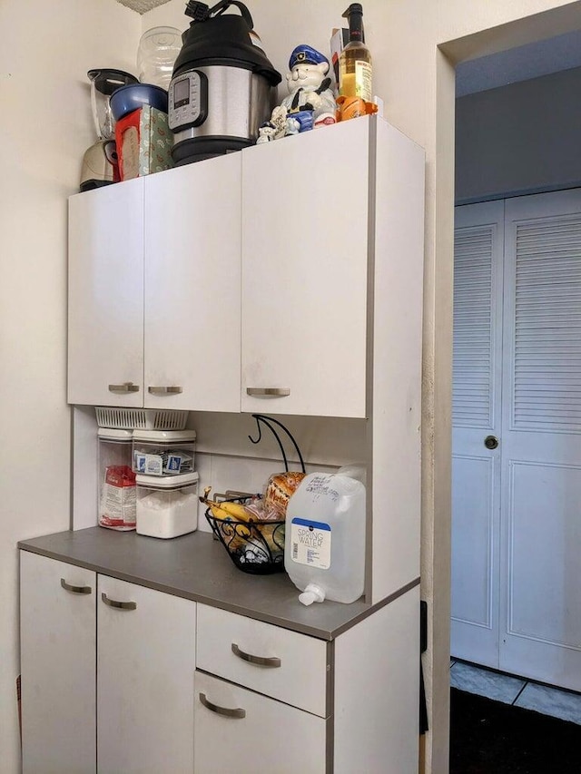 kitchen with dark countertops and white cabinetry