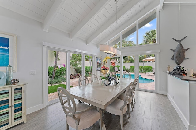 dining area with high vaulted ceiling, light hardwood / wood-style floors, french doors, and beamed ceiling