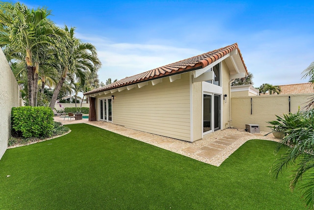 back of property with a yard and a patio