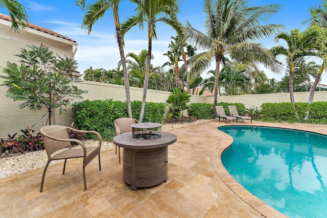 view of pool featuring a patio and a fire pit