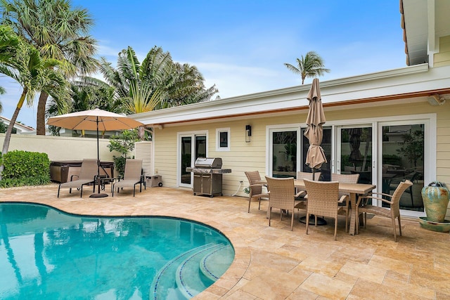 view of swimming pool with a grill, a hot tub, and a patio area