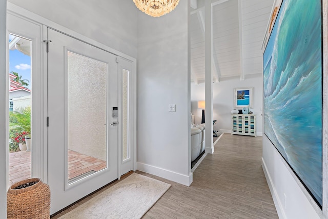 entrance foyer with beam ceiling, light hardwood / wood-style flooring, and wooden ceiling