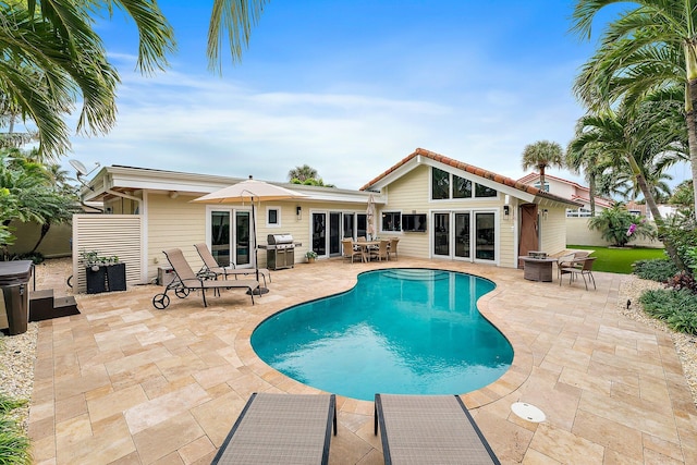 view of pool featuring grilling area and a patio