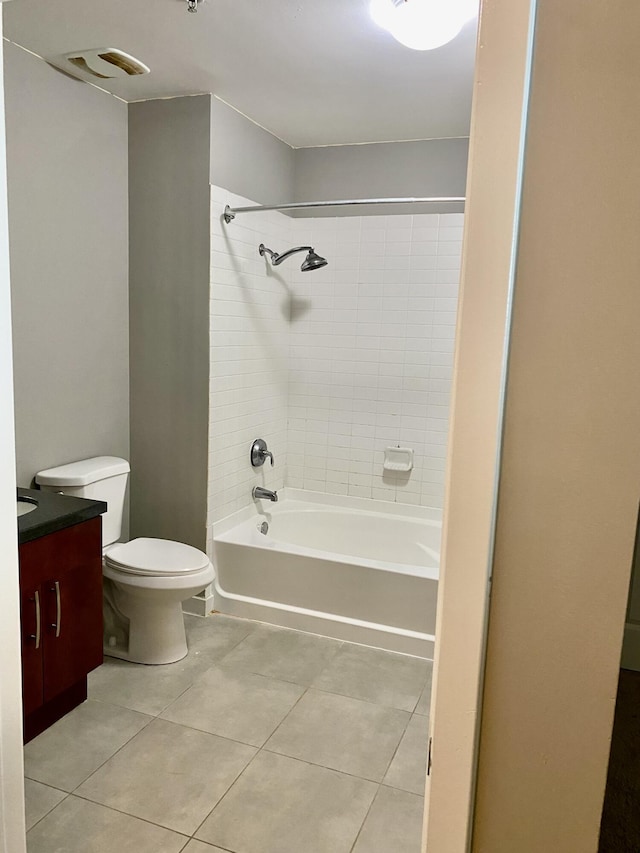 full bathroom with tiled shower / bath, vanity, tile patterned floors, and toilet