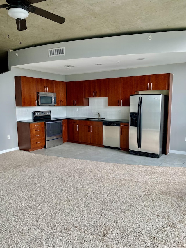 kitchen with ceiling fan, stainless steel appliances, sink, and decorative backsplash