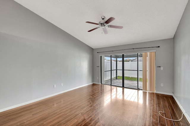 empty room featuring ceiling fan, lofted ceiling, dark hardwood / wood-style flooring, and a textured ceiling