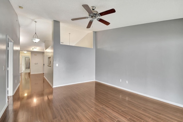 spare room featuring wood-type flooring, lofted ceiling, and ceiling fan