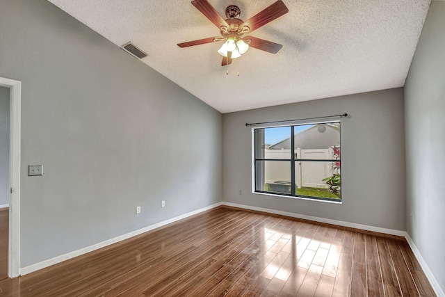 empty room with ceiling fan, wood-type flooring, and a textured ceiling