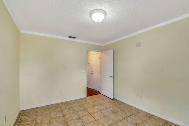 tiled spare room with ornamental molding and a textured ceiling