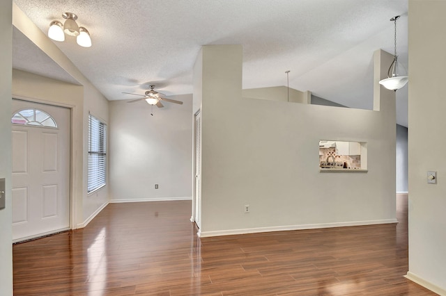 entrance foyer featuring lofted ceiling, a textured ceiling, dark hardwood / wood-style floors, and ceiling fan