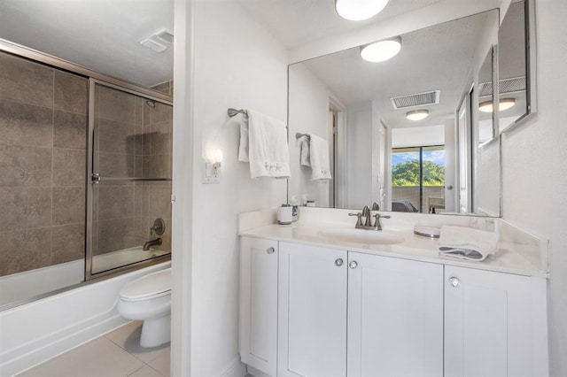 full bathroom featuring enclosed tub / shower combo, tile patterned floors, toilet, and vanity