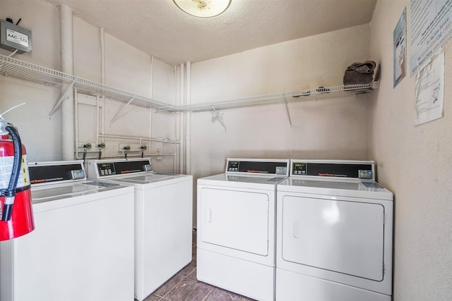 washroom with a textured ceiling and independent washer and dryer