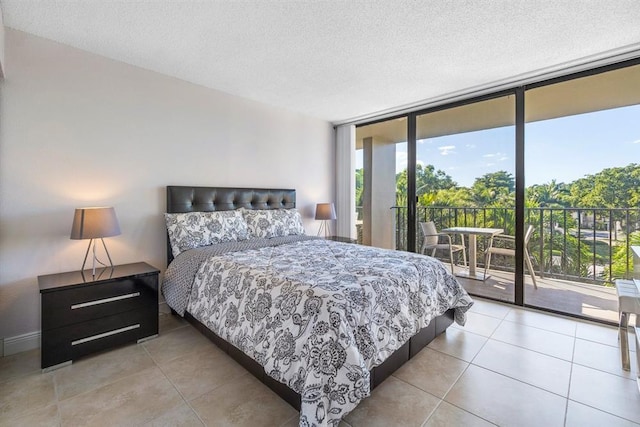 tiled bedroom featuring expansive windows, access to exterior, and a textured ceiling