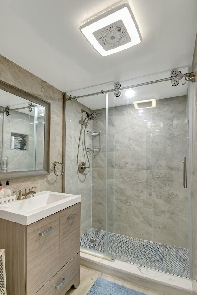 bathroom featuring vanity, hardwood / wood-style floors, backsplash, and walk in shower