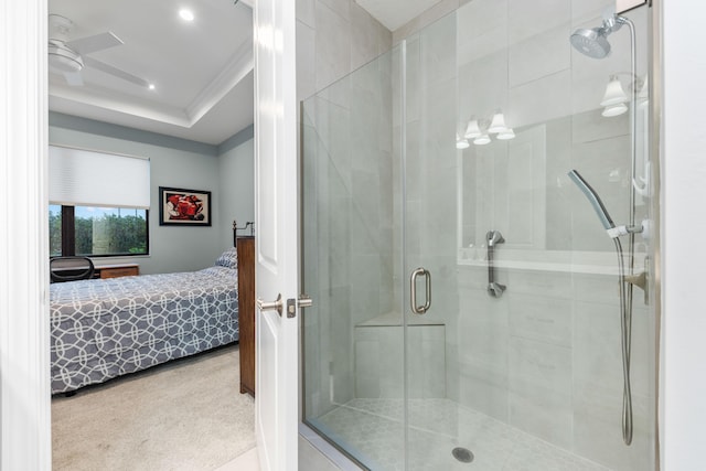 bathroom with ornamental molding, a tray ceiling, and a shower with shower door