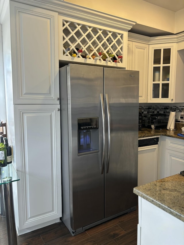 kitchen featuring white cabinetry, dark hardwood / wood-style floors, stainless steel fridge, and dark stone counters