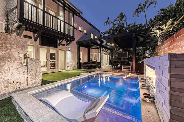 view of swimming pool with an in ground hot tub, pool water feature, a pergola, an outdoor living space, and a patio area