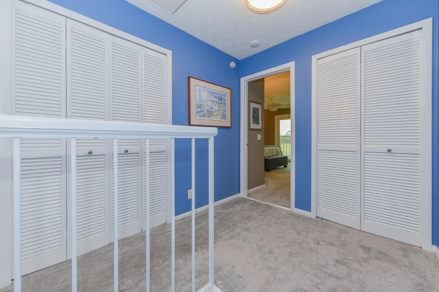 unfurnished bedroom featuring light carpet and a textured ceiling