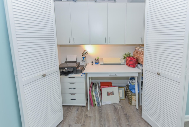 office area with built in desk and light hardwood / wood-style flooring