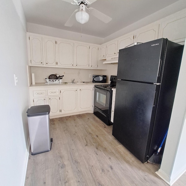 kitchen with black appliances, sink, white cabinets, ceiling fan, and light hardwood / wood-style floors