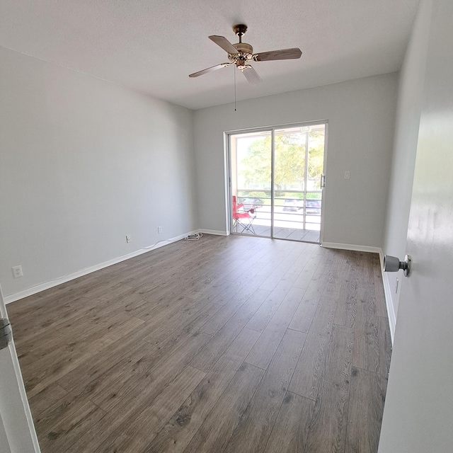 spare room featuring a textured ceiling, dark wood-type flooring, and ceiling fan