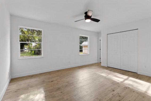 unfurnished bedroom with ceiling fan, a closet, and light wood-type flooring