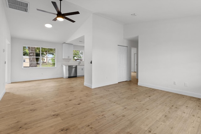 unfurnished living room featuring high vaulted ceiling, light wood-type flooring, sink, and ceiling fan