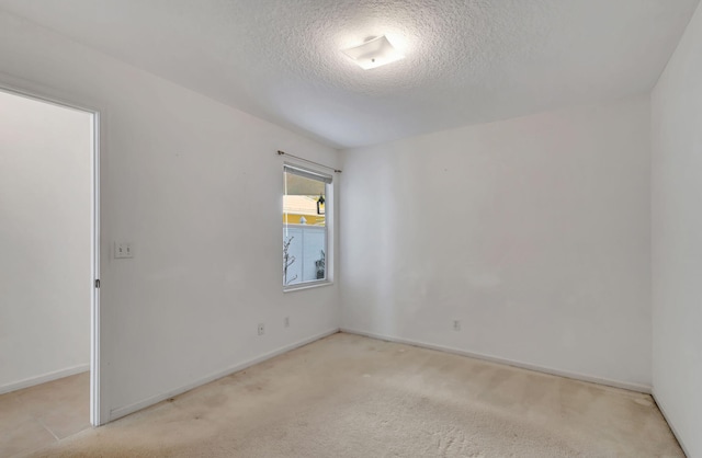 carpeted spare room with a textured ceiling