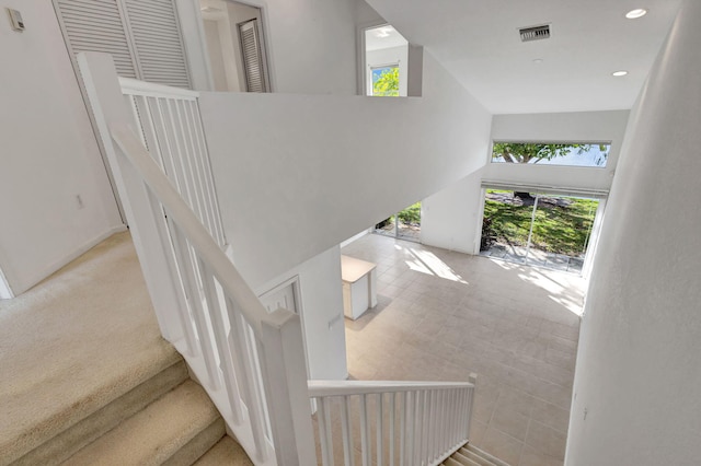 staircase featuring carpet flooring and a towering ceiling