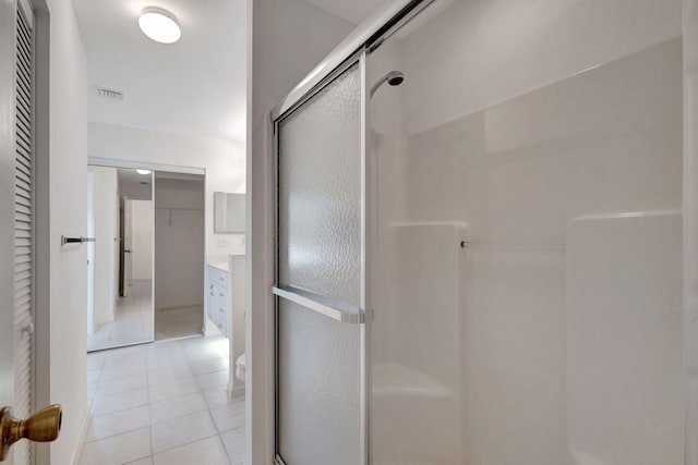 bathroom with vanity, toilet, a shower with shower door, and tile patterned flooring