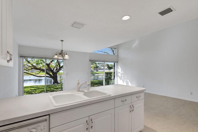 kitchen with dishwashing machine, sink, pendant lighting, a water view, and white cabinets