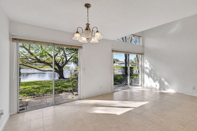 tiled spare room with a water view and a notable chandelier