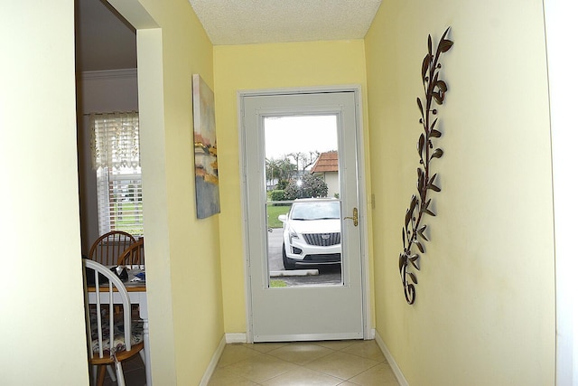 doorway to outside featuring a textured ceiling and light tile patterned floors