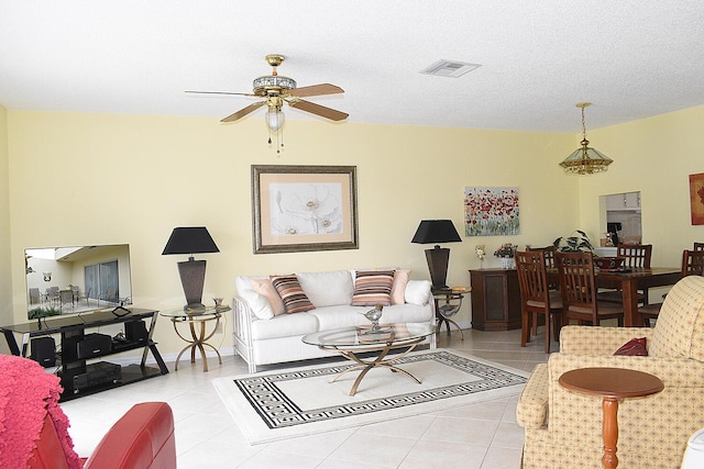 tiled living room with ceiling fan and a textured ceiling