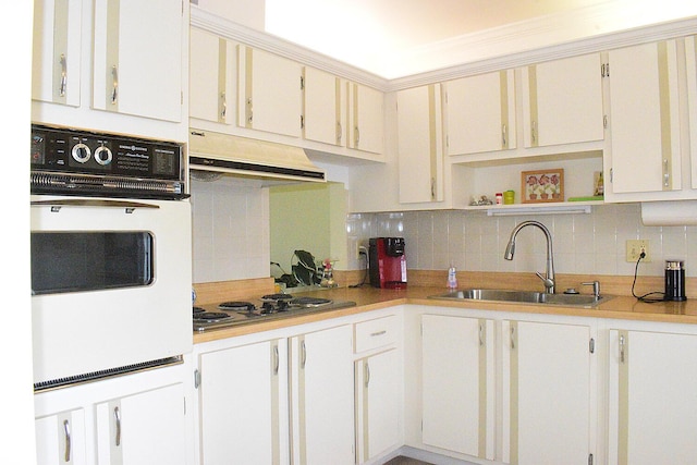 kitchen with sink, decorative backsplash, stainless steel gas cooktop, and white oven