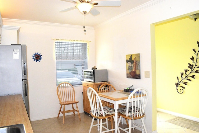 dining room featuring crown molding, ceiling fan, and light tile patterned flooring