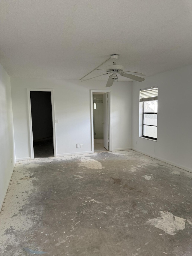 unfurnished room with a textured ceiling and a ceiling fan