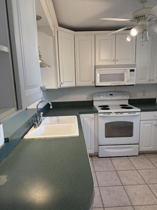 kitchen featuring ceiling fan, white appliances, a sink, white cabinets, and dark countertops